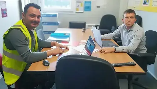 Construction Contracting Management NVQ Level 6 assessor with candidate reviewing commercial documents
