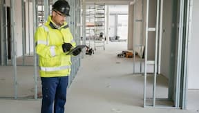 Occupational health & safety supervisor carrying out his work duties on a construction site