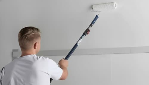 NVQ Level 2 painter decorating the wall with roller