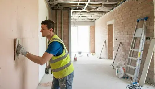 Plastering NVQ Level 2 plasterer applying finish on site